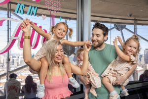 A family viewing the downtown Dallas skyline at night from Reunion Tower’s observation deck
