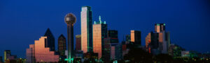 A wide panoramic shot of Dallas at sunset, with Reunion Tower prominently featured.